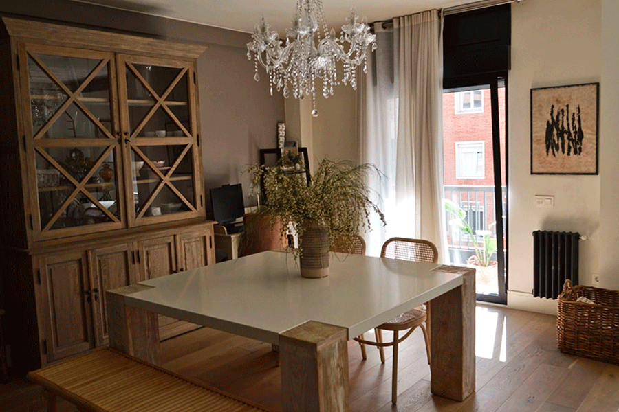 El comedor, con alacena de madera y lámpara de araña, da paso a la terraza. Tradición, elegancia y modernidad serena.