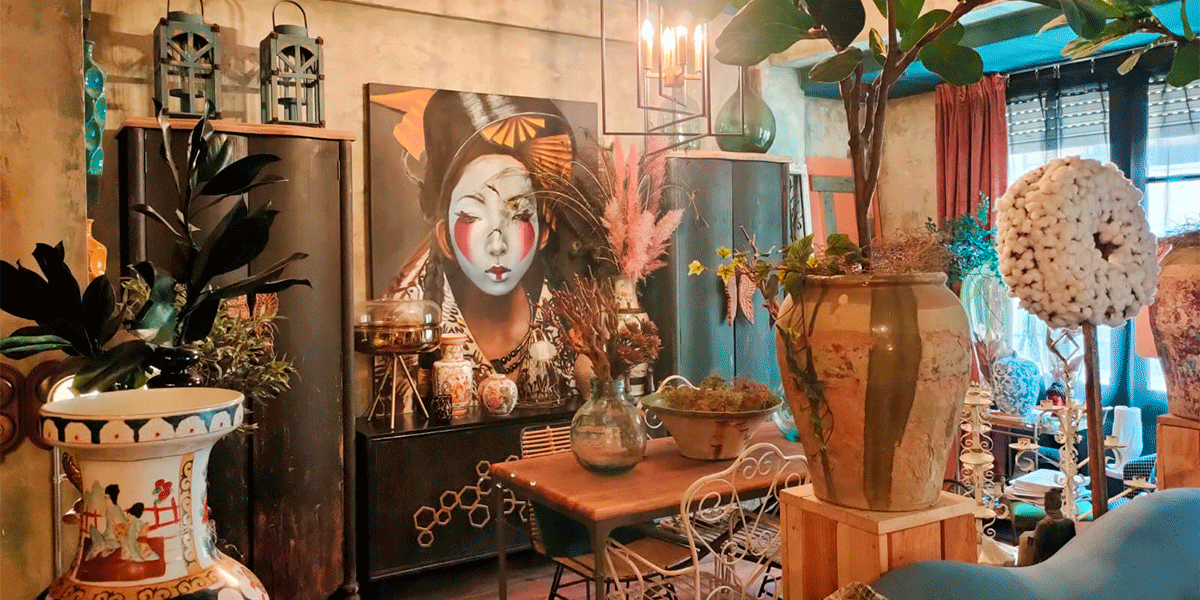 El salón desde otro ángulo, presidido por una gran pintura de estilo oriental. Plantas, cerámica y carácter.